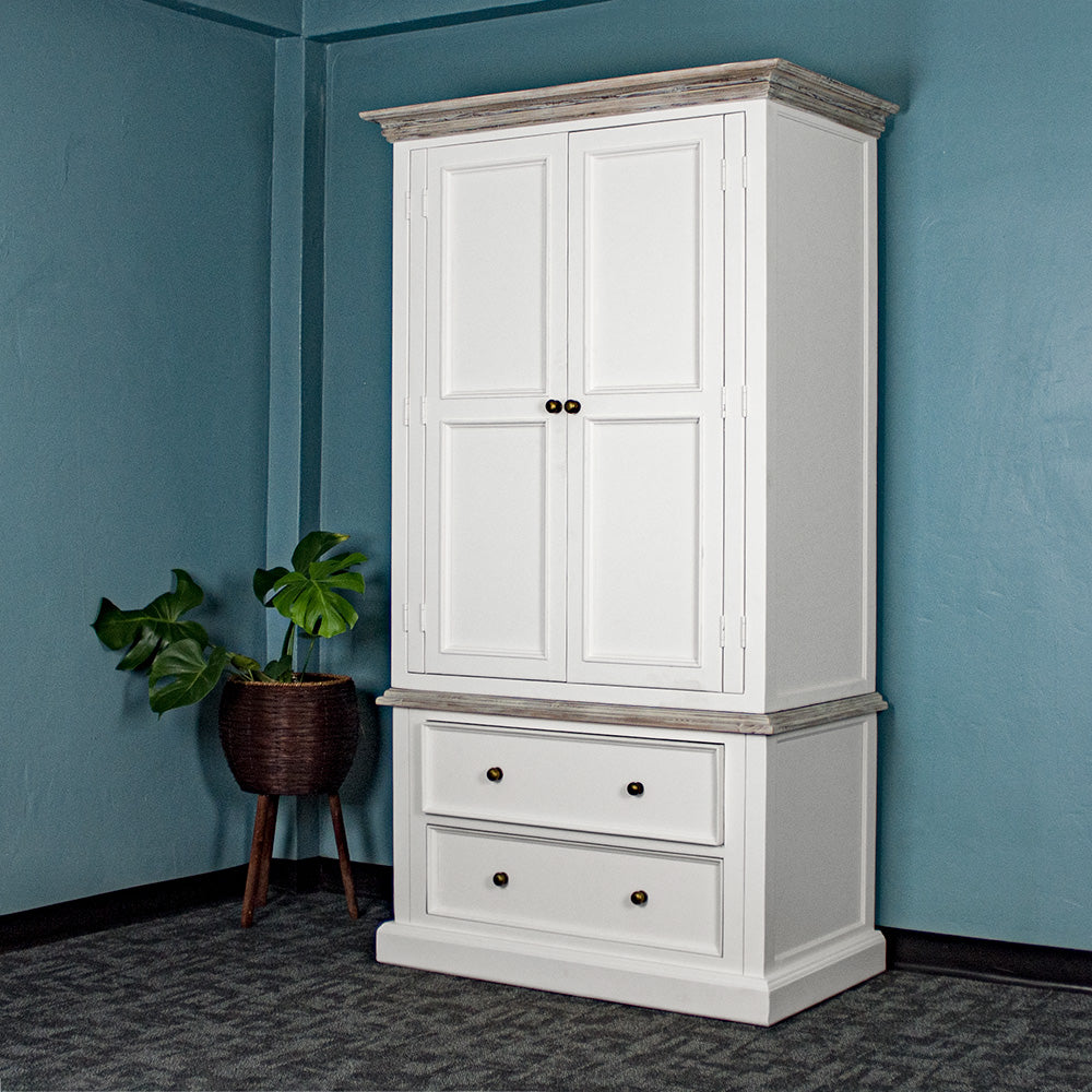 An overall view of the Biarritz Two-piece Wardrobe. There is a free standing potted plant next to it.