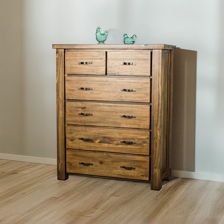 The front of the Botanica Six Drawer Tallboy, with two blue glass ornaments on top.
