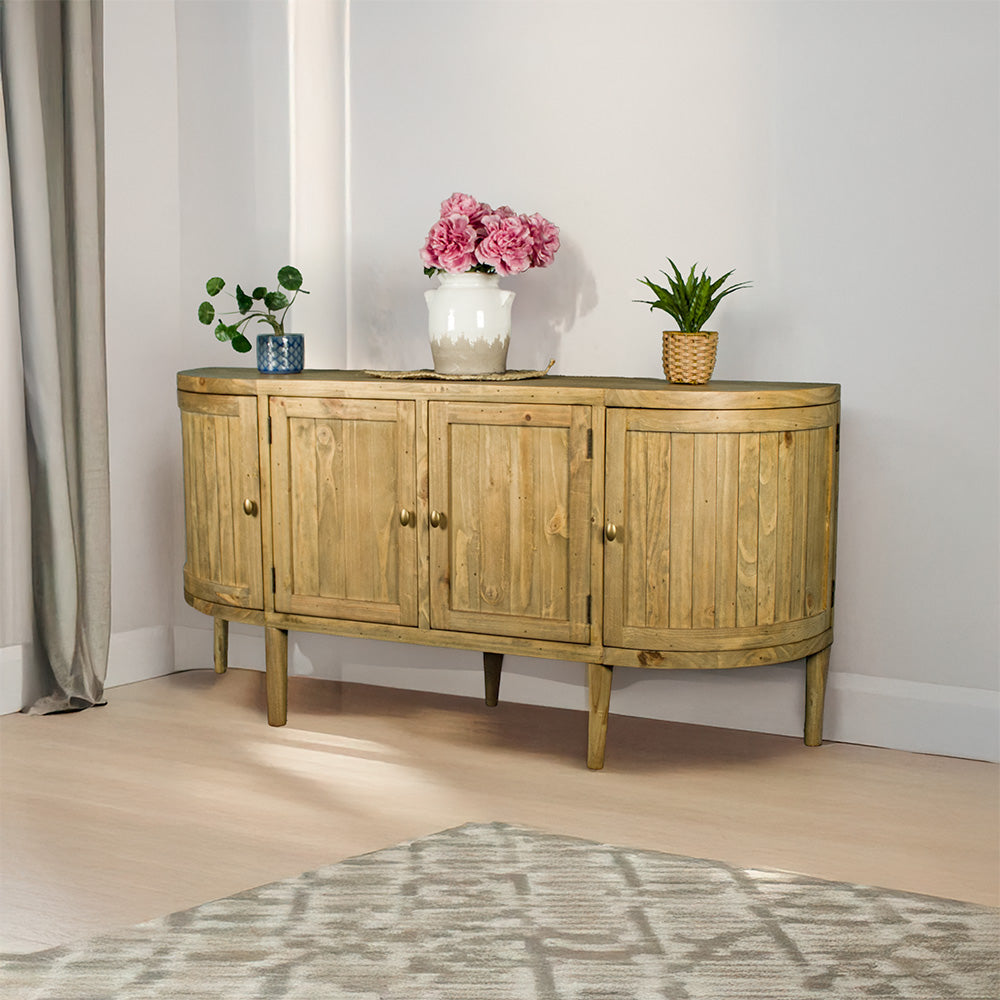 The front of the Buffalo Recycled Pine Curved Buffet. There are three potted plants on top, with a rattan leaf in the middle.