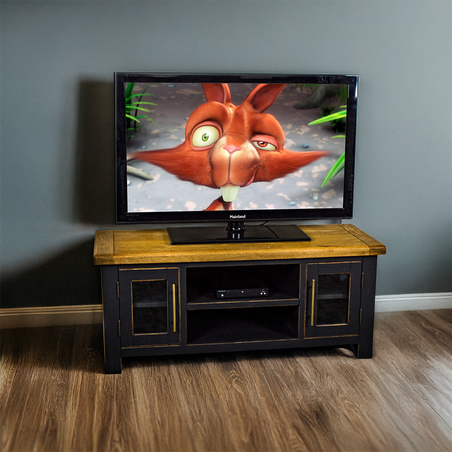 The front of the Cascais Oak-Top TV Unit. There is a large TV on top and a DVD player on the top shelf in the middle.