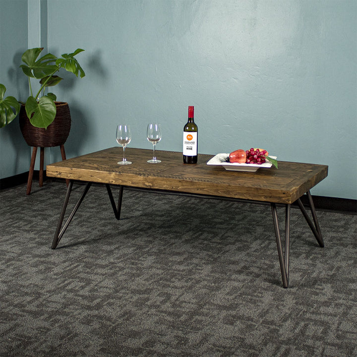 Front view of the Paddington Recycled Pine Coffee Table. There is a fruit platter, two glasses and a glass bottle on top. There is a standing potted plant in the background.