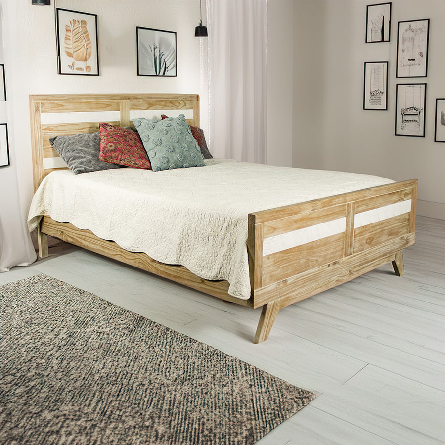 The front of the Soho Queen Size Slat Bed Frame in a modern bedroom, covered in blankets and pillows.