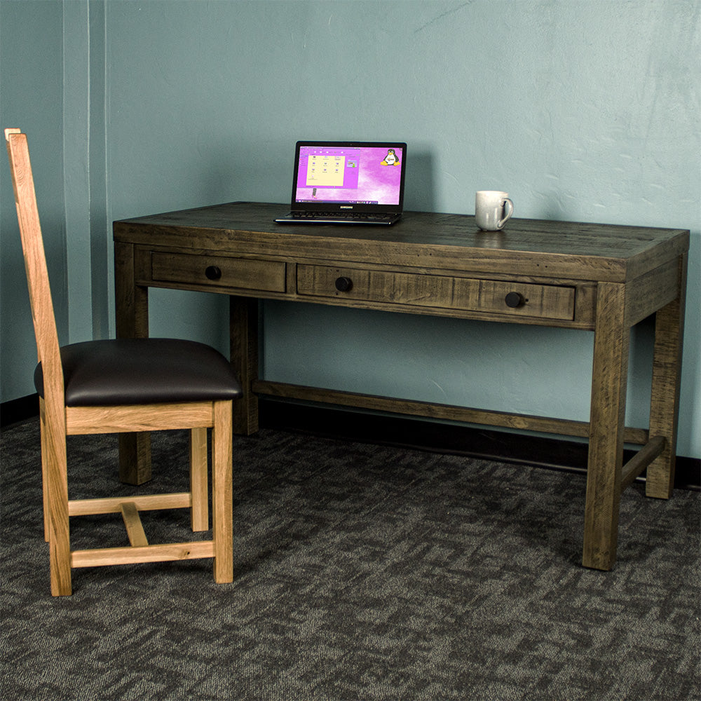 Front of the Stonemill Recycled Pine Desk. There is an oak leather chair in front and a laptop and coffee mug on top.