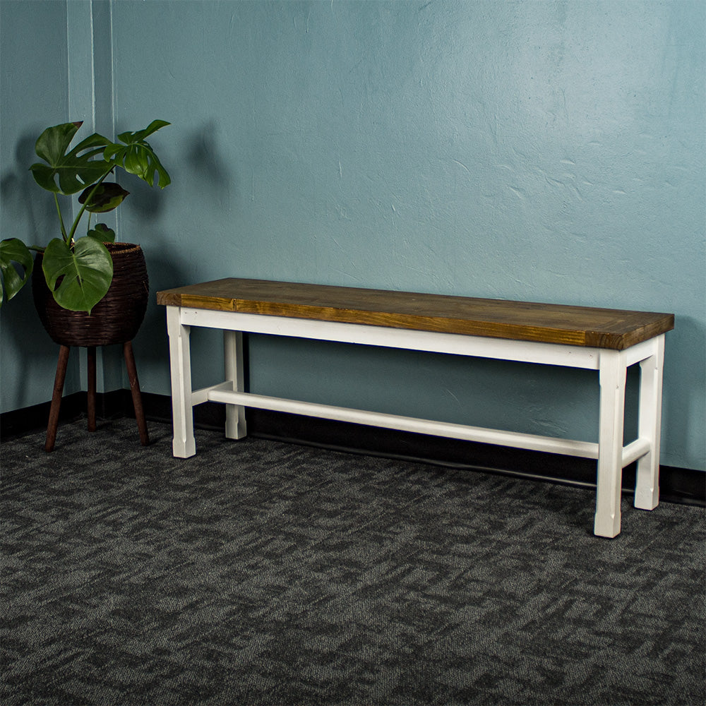 Front of the Tuscan Recycled Pine Bench. There is a free standing potted plant next to it.