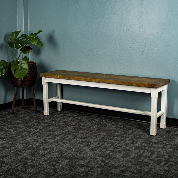 Front of the Tuscan Recycled Pine Bench. There is a free standing potted plant next to it.