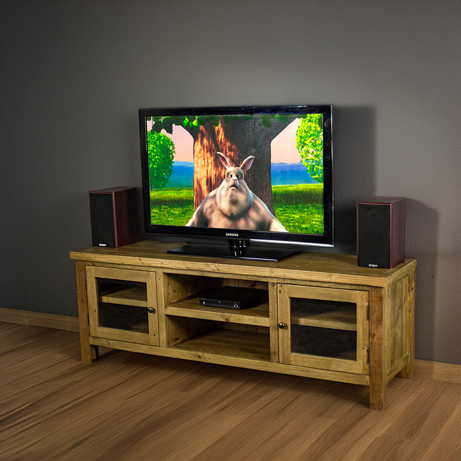 An overall view of the Ventura Recycled Pine Medium TV Unit. There is a TV on top, with two bookcase speakers on either side and a DVD player on the top shelf in the middle of the unit.