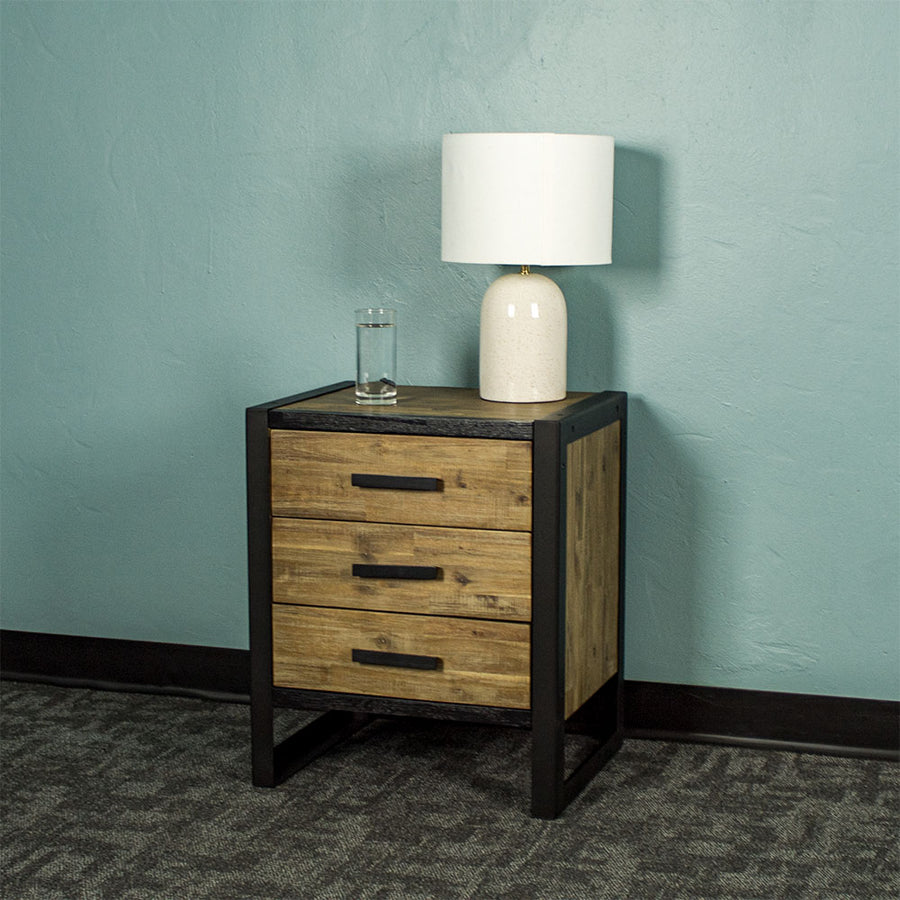 Front of the Victor 3 Drawer Bedside Cabinet. There is a lamp and a glass of water on top.