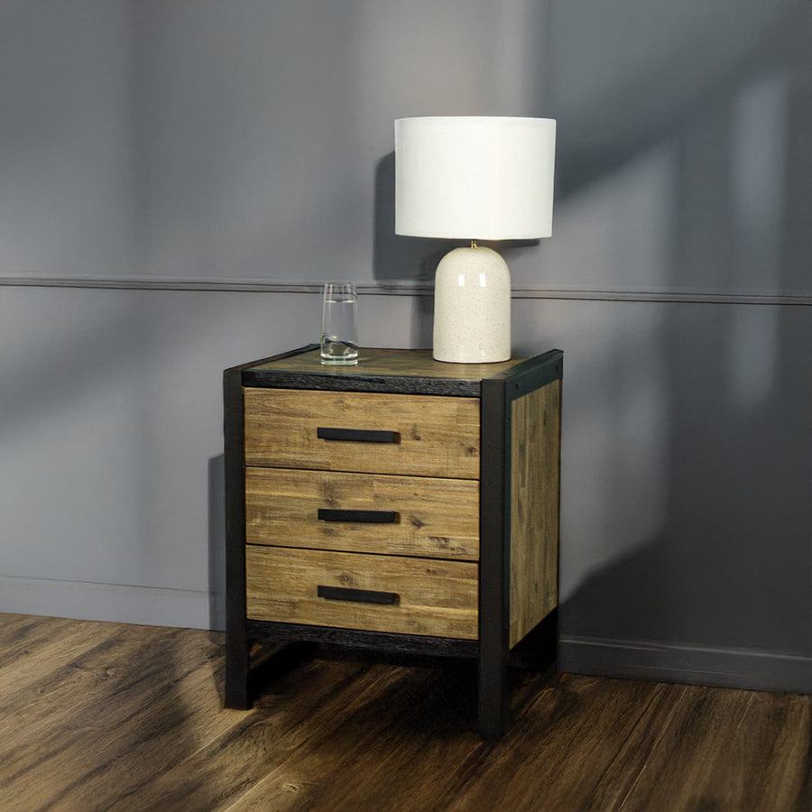 Front of the Victor 3 Drawer Bedside Cabinet. There is a lamp and a glass of water on top.