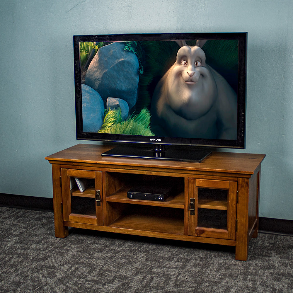 The front of the Montreal Entertainment Unit. There is a large TV on top, a DVD player on the top shelf, and two DVD cases in the left cabinet.