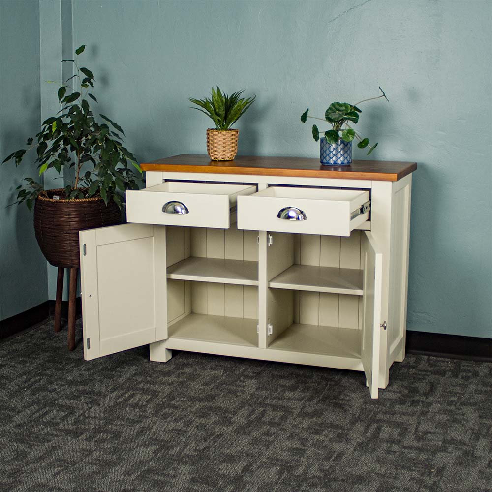 The front of the Alton 2 Door 2 Drawer NZ Pine Buffet with its drawers and doors open. There are two potted plants on top with a free standing potted plant to the left.