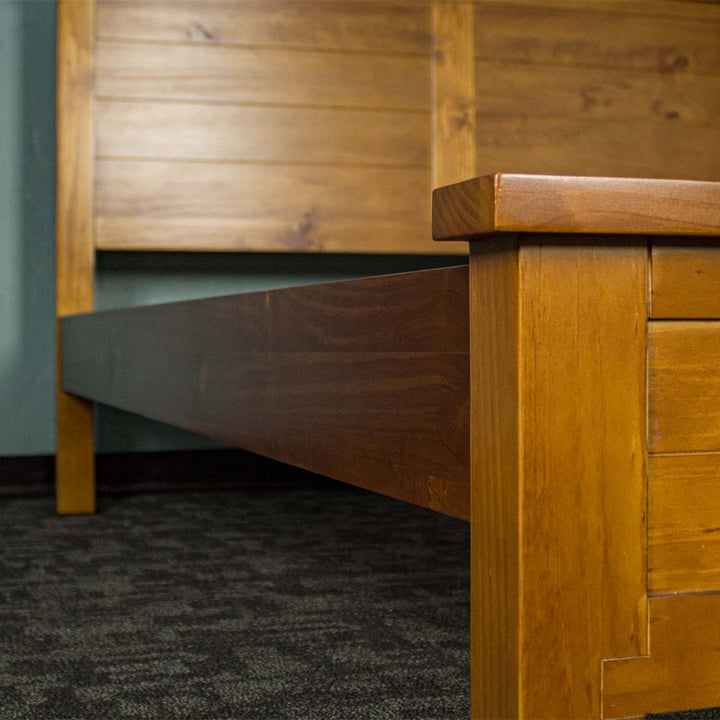 The side rails of the Alton Rimu-stained NZ Pine Queen Bed Frame.