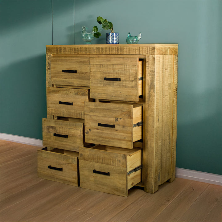 The front of the Amarillo Seven-Drawer Tallboy with its drawers open. There are two glass ornaments on top with a potted plant in between.