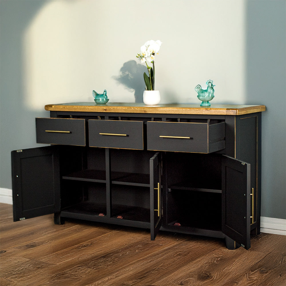 Front view of the Cascais Large Black Buffet with its drawers and doors open. There are two blue glass ornaments and a flower pot on top.