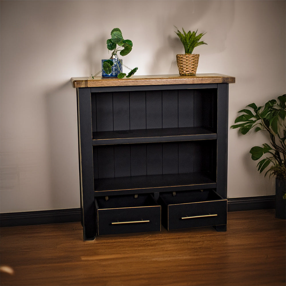 The front of the Cascais Oak Low Bookcase with its drawers open. There are two potted plants on top.