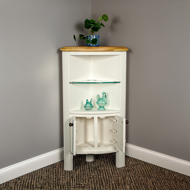 The front of the Loire Oak Corner Display Unit with its doors open. There is a potted plant on top and two blue glass ornaments below the glass shelf in the middle.