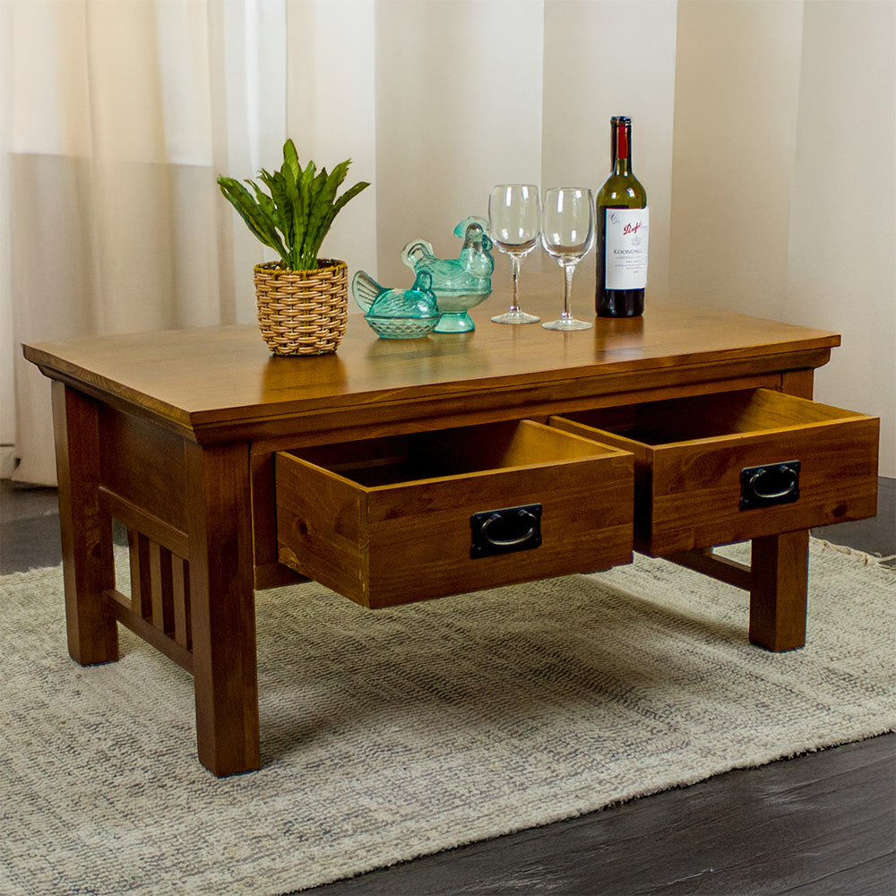 The front of the Montreal Coffee Table with 2 Drawers with its drawers open. There is a potted plant, two blue glass ornaments, two wine glasses and a bottle of wine on top.