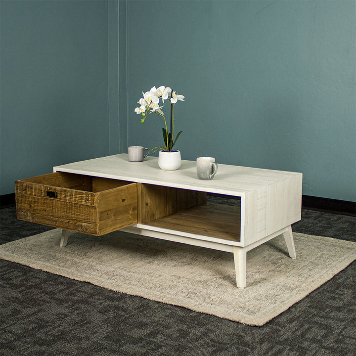 The front of the Nova Recycled Pine Coffee Table with its drawer open. There are two coffee mugs and a pot of flowers on top.