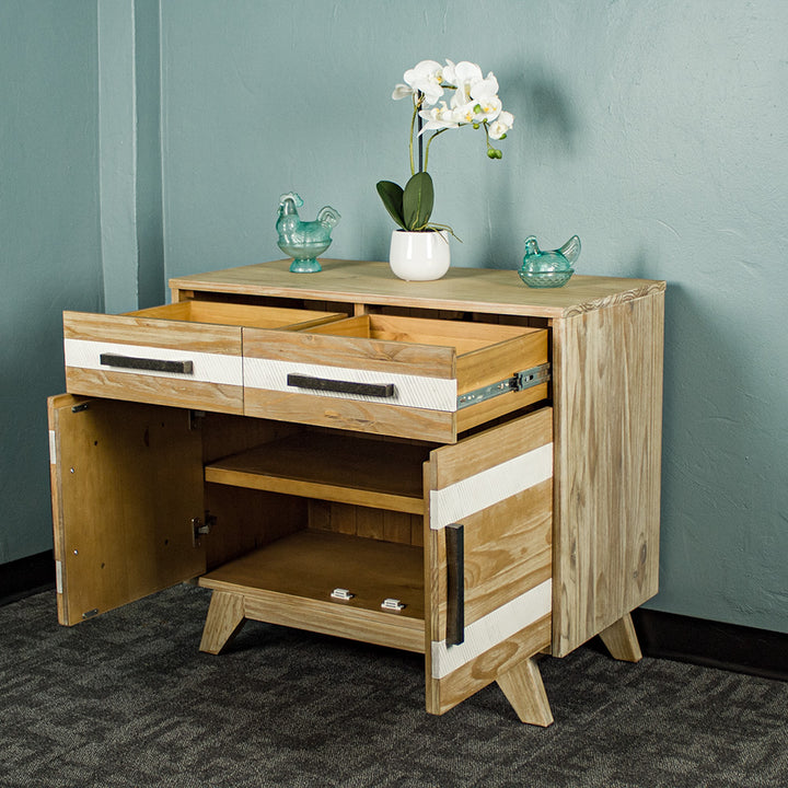 The front of the Soho 2 Door 2 Drawer NZ Pine Buffet Sideboard with its drawers and doors open. There are two blue glass ornaments on top and a pot of white flowers in between.