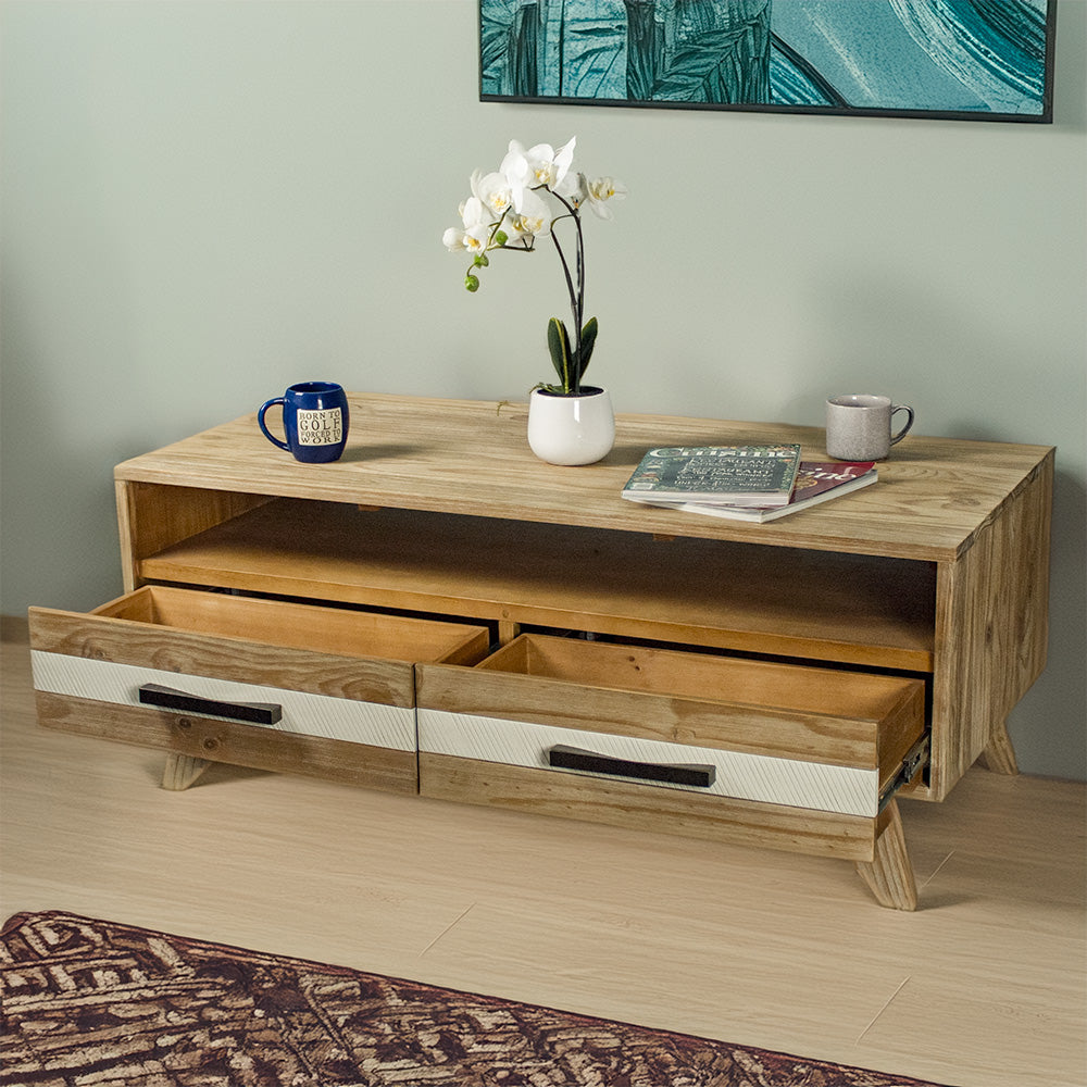 The front of the Soho 4 Drawer NZ Pine Coffee Table with its drawers open. There are two coffee mugs, two magazines and a small pot of white flowers on top of the table.
