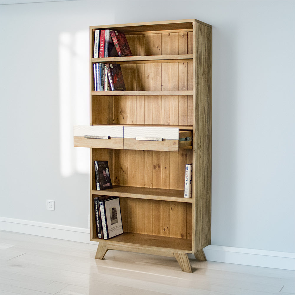 The front of the Soho Tall Bookcase with its drawers open. There are books on each shelf.