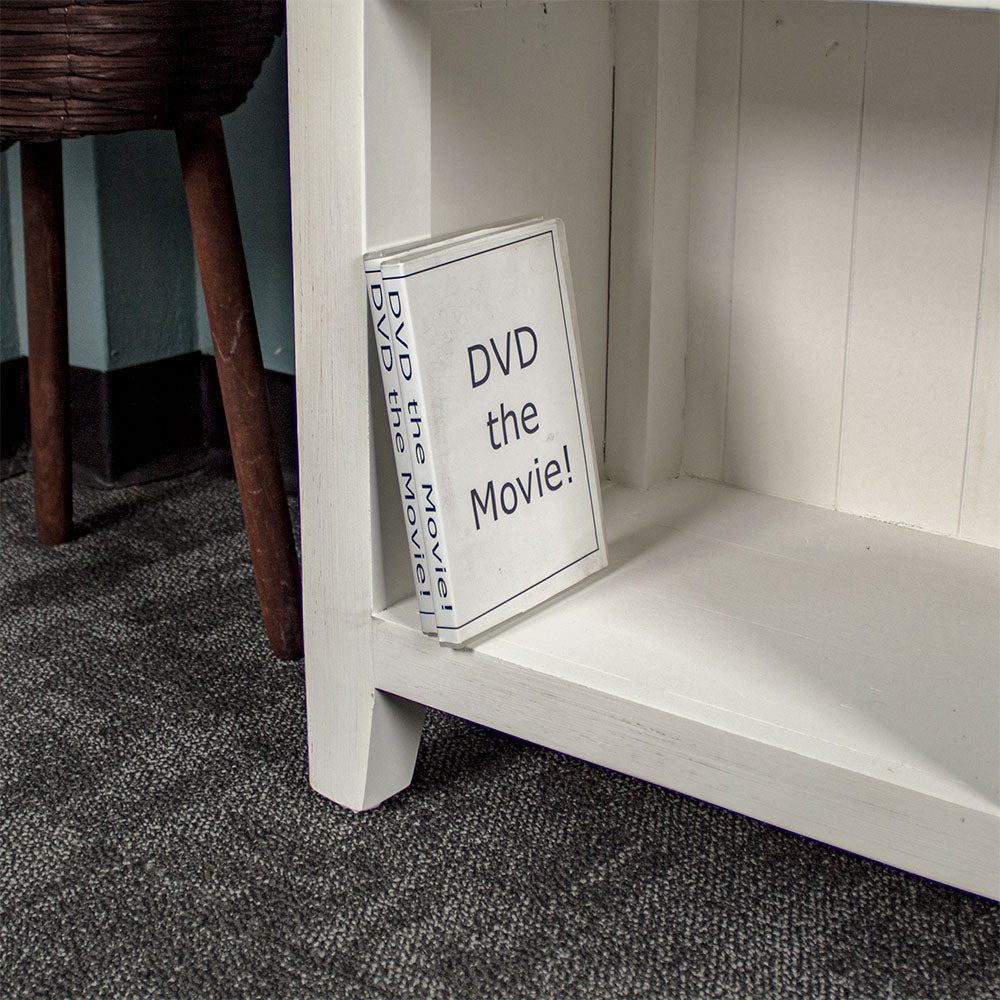 Close up of the bottom shelf of the Tuscan Recycled Pine Low Bookcase, with two DVD cases for scale.