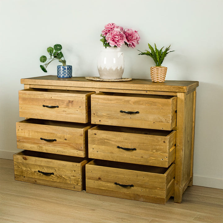 The front of the Ventura Recycled Pine Lowboy with its drawers open. There are three potted plants on top.