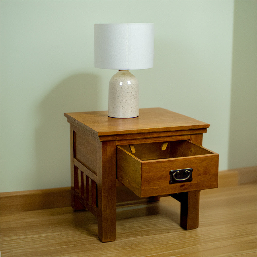 The front of the Montreal Pine Lamp Table, with its drawer open. There is a lamp on top.