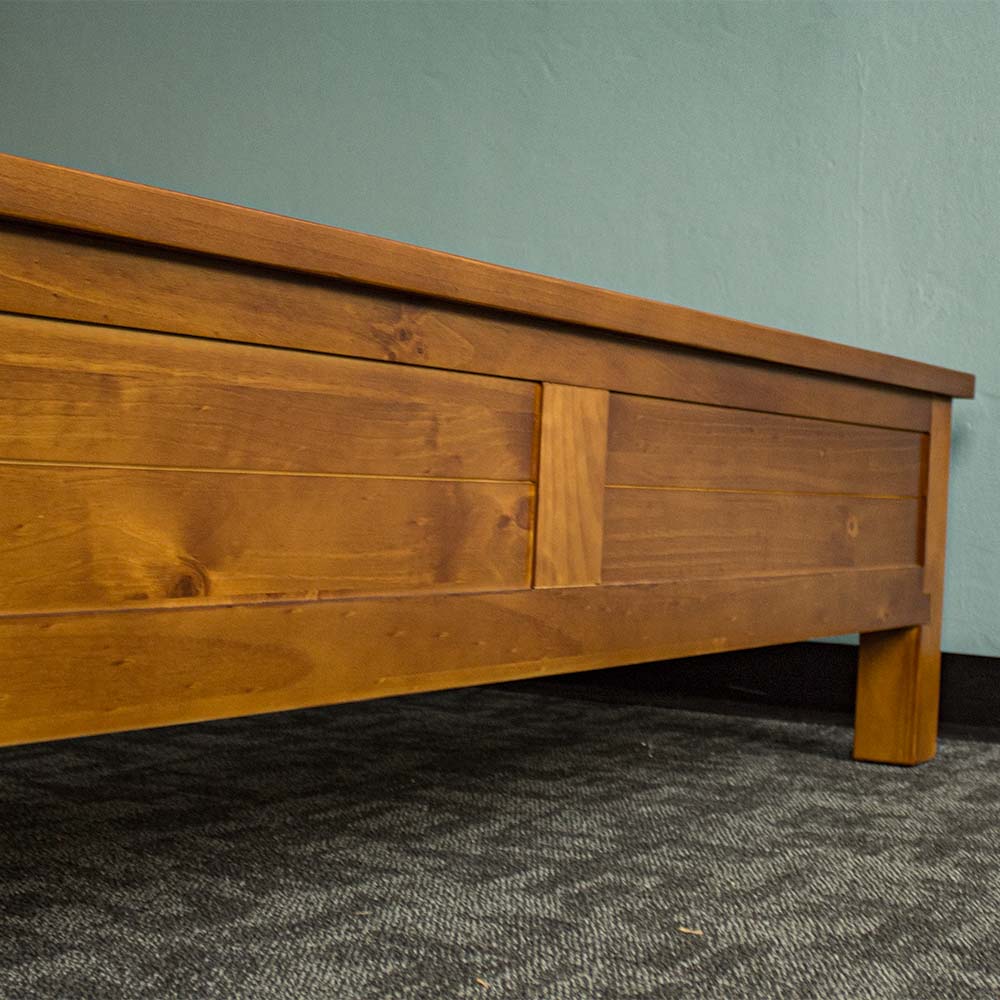 The side of the footboard on the Alton Rimu-stained NZ Pine Queen Bed Frame.