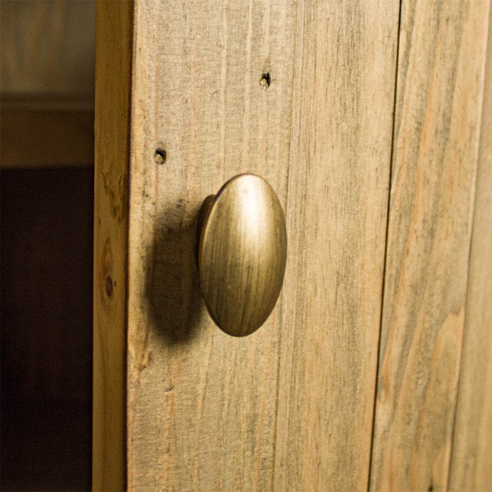 A close up of the metal handle on the doors of the Buffalo Recycled Pine Curved Buffet.