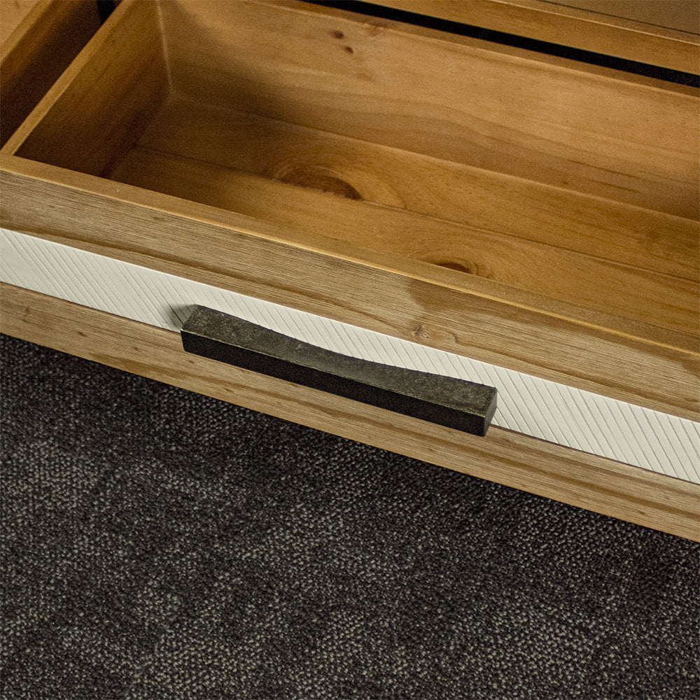 A close up of the brushed black metal handle on the drawers of the Soho 4 Drawer NZ Pine Coffee Table.