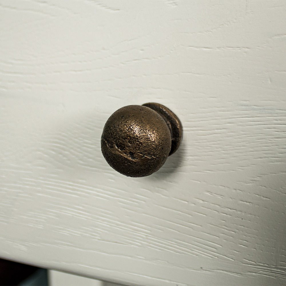 A close up of the brushed brass coloured metal handle on the drawer of the Loire Oak Console Table