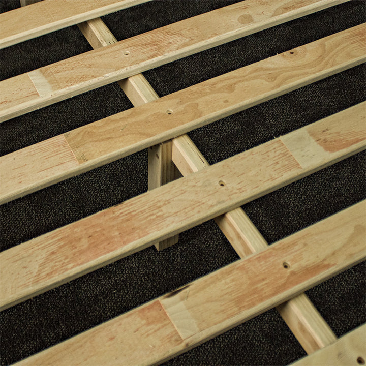 A close up of the wooden slats and support bars on the Botanica Queen Slat Bed Frame.