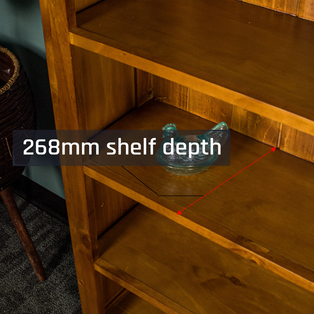 A low angle shot of the shelving on the Montreal Large Pine Bookcase. There is a blue glass ornament in the shape of a chicken on the shelf.