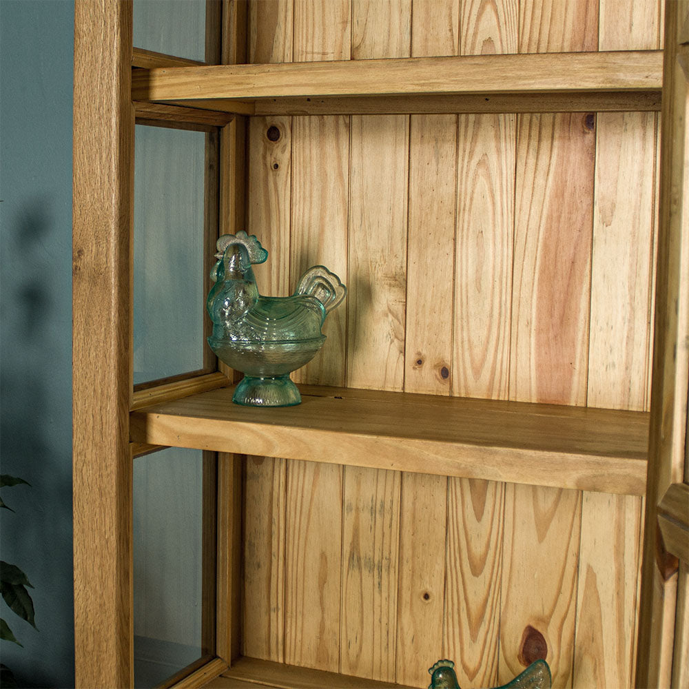 A closer view of the shelf on the Versailles Small Display Cabinet, which has a blue glass ornament in the shape of a chicken.