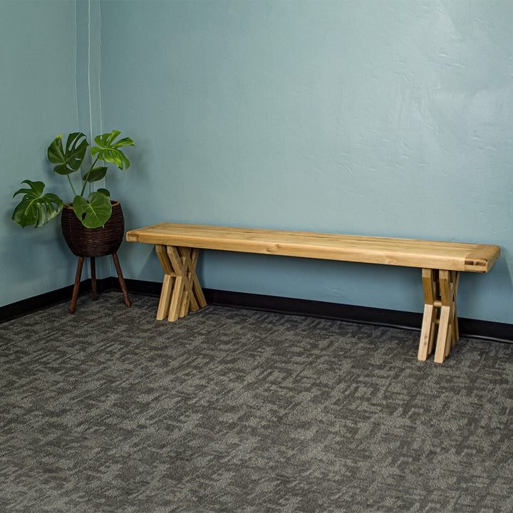 An overall view of the Arpege Oak Cross Leg 2m Bench Seat. There is a free standing potted plant next to it.