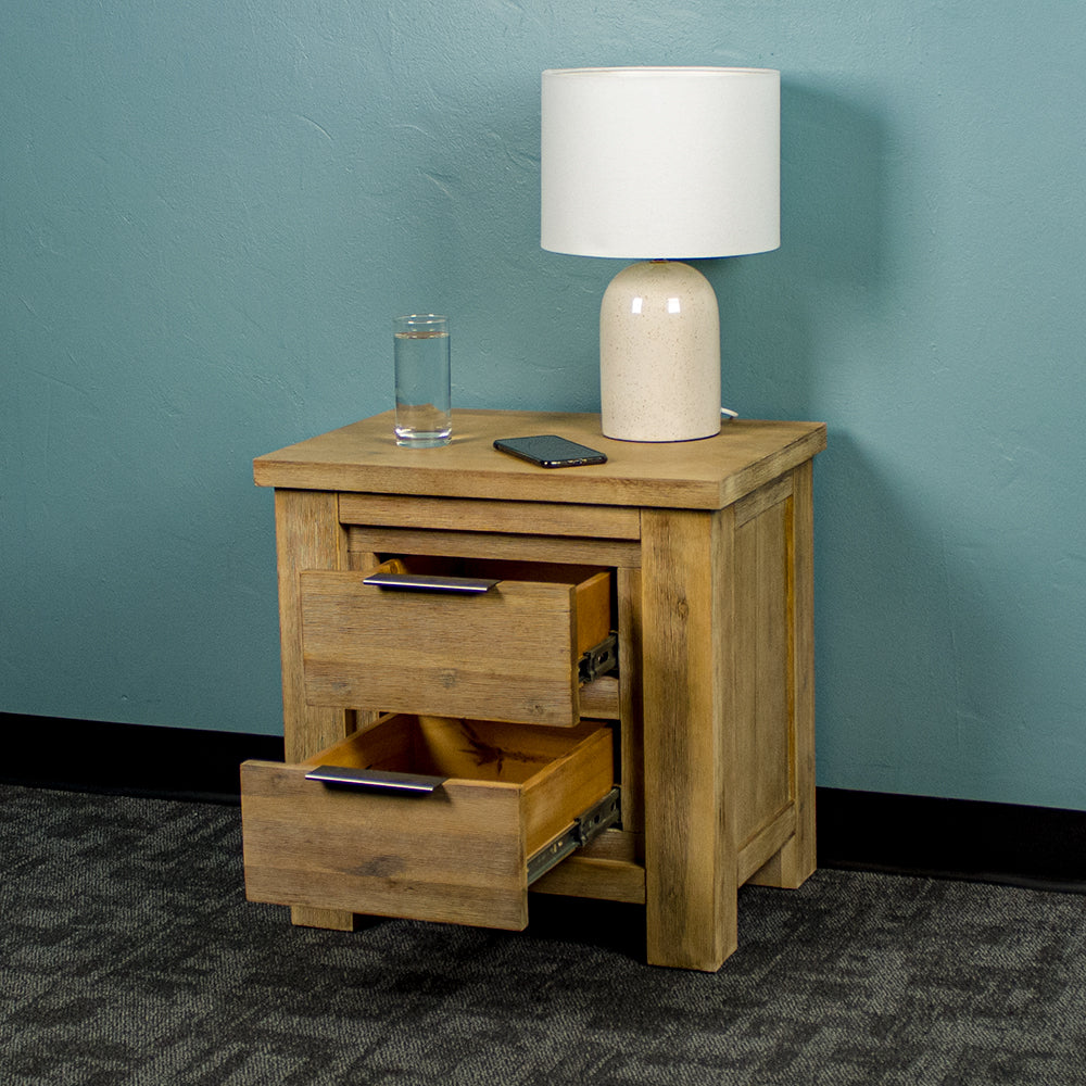 The front of the Mars Two-Drawer Bedside Cabinet with its drawers open. There is a lamp, a glass of water and a phone on top.