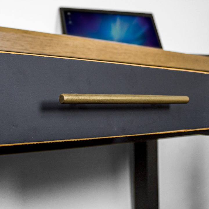 A close up of the gold coloured metal handle on the drawer of the Cascais Black Desk.